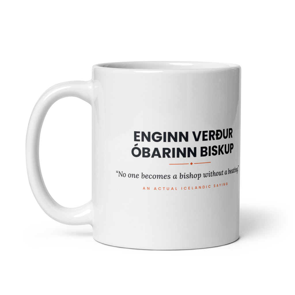 White 11 oz Enginn verður óbarinn biskup mug, handle on the left, showing the repeated saying on the other side.