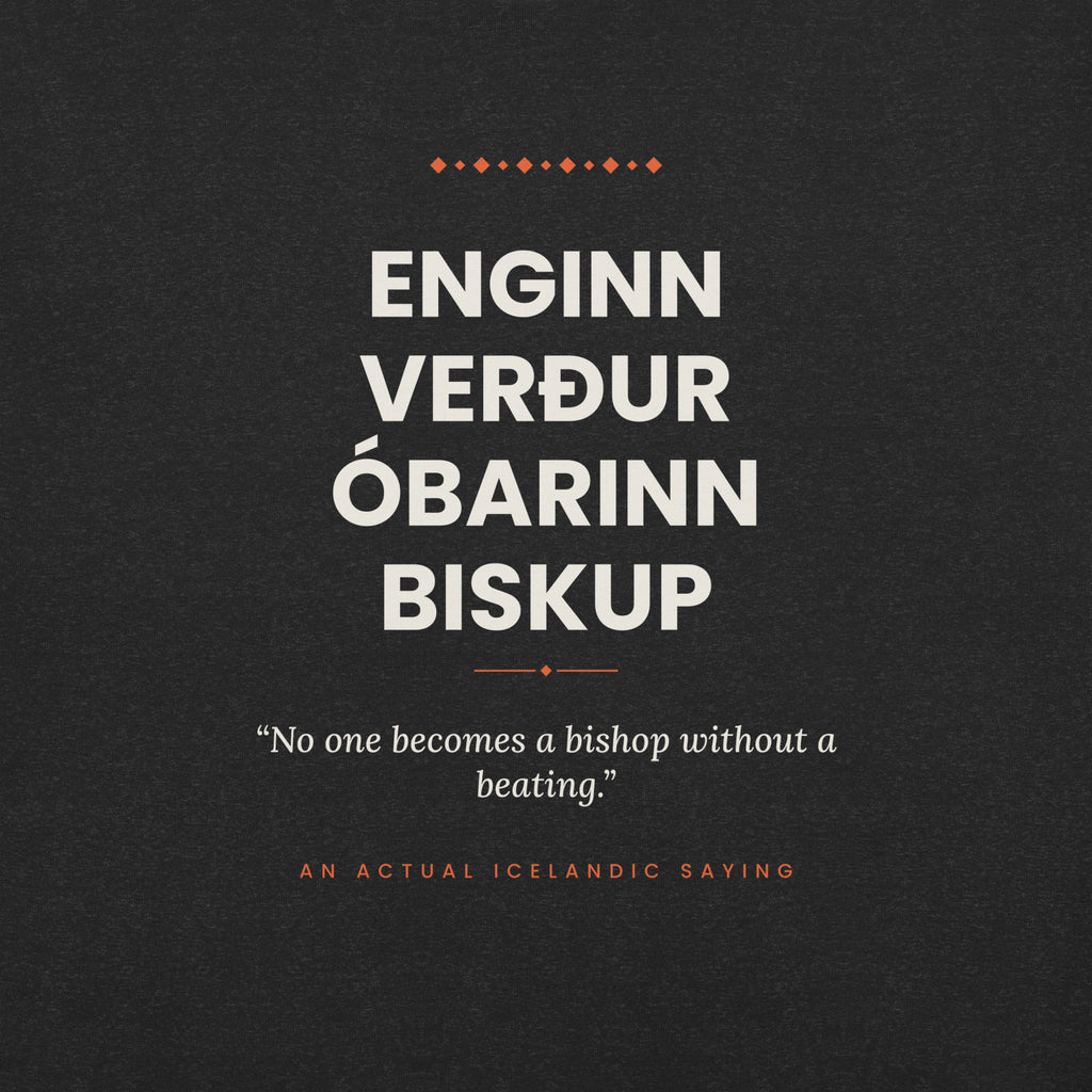 Close-up of the Enginn verður óbarinn biskup front print, showing cream lettering, English translation and coral accents on Black Heather fabric.