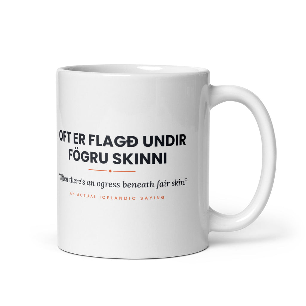 White 11 oz Oft er flagð undir fögru skinni mug, handle on the right, showing black lettering, English translation and coral accents.