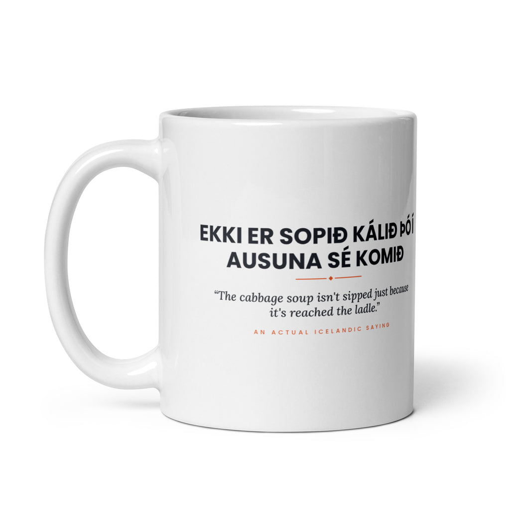 White 11 oz Ekki er sopið kálið þó í ausuna sé komið mug, handle on the left, showing the repeated saying on the other side.