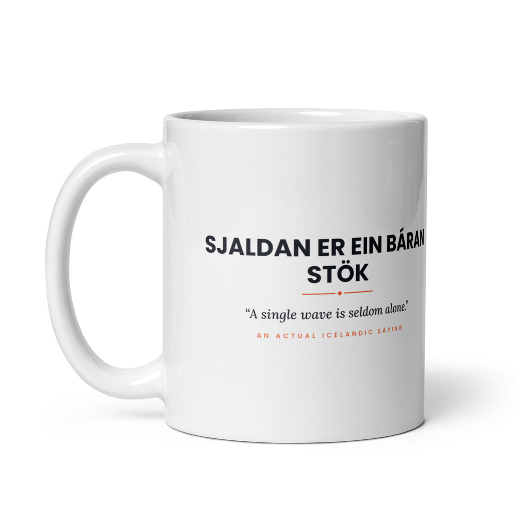 White 11 oz Sjaldan er ein báran stök mug, handle on the left, showing the repeated saying on the other side.