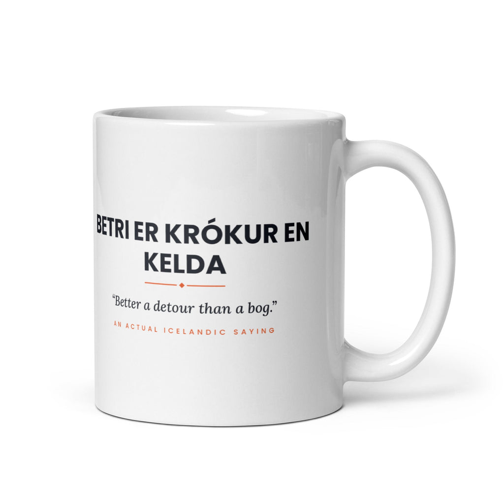 White 11 oz Betri er krókur en kelda mug, handle on the right, showing black lettering, English translation and coral accents.