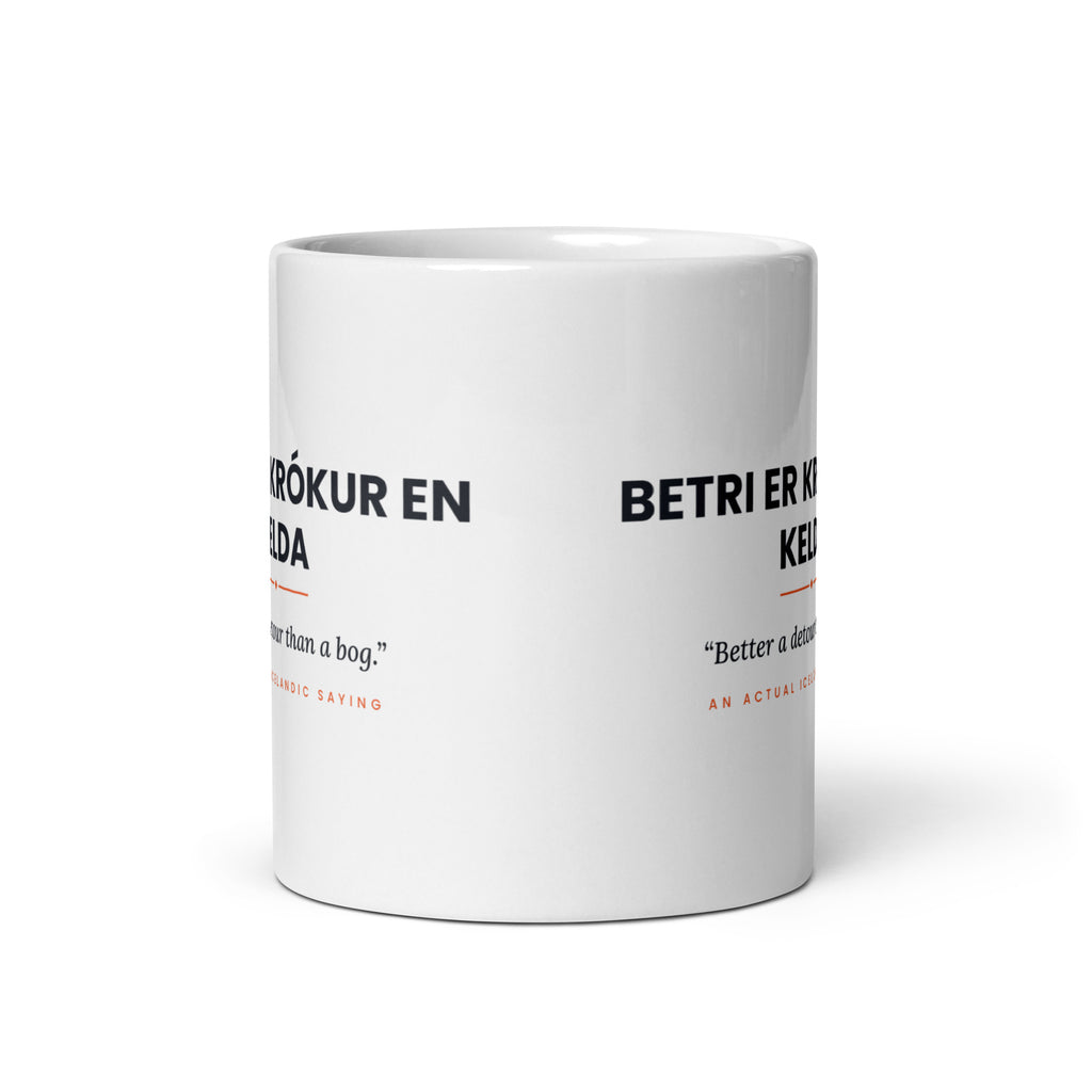 View opposite the handle of the white 11 oz Betri er krókur en kelda mug, showing the gap between the two repeats of the design.