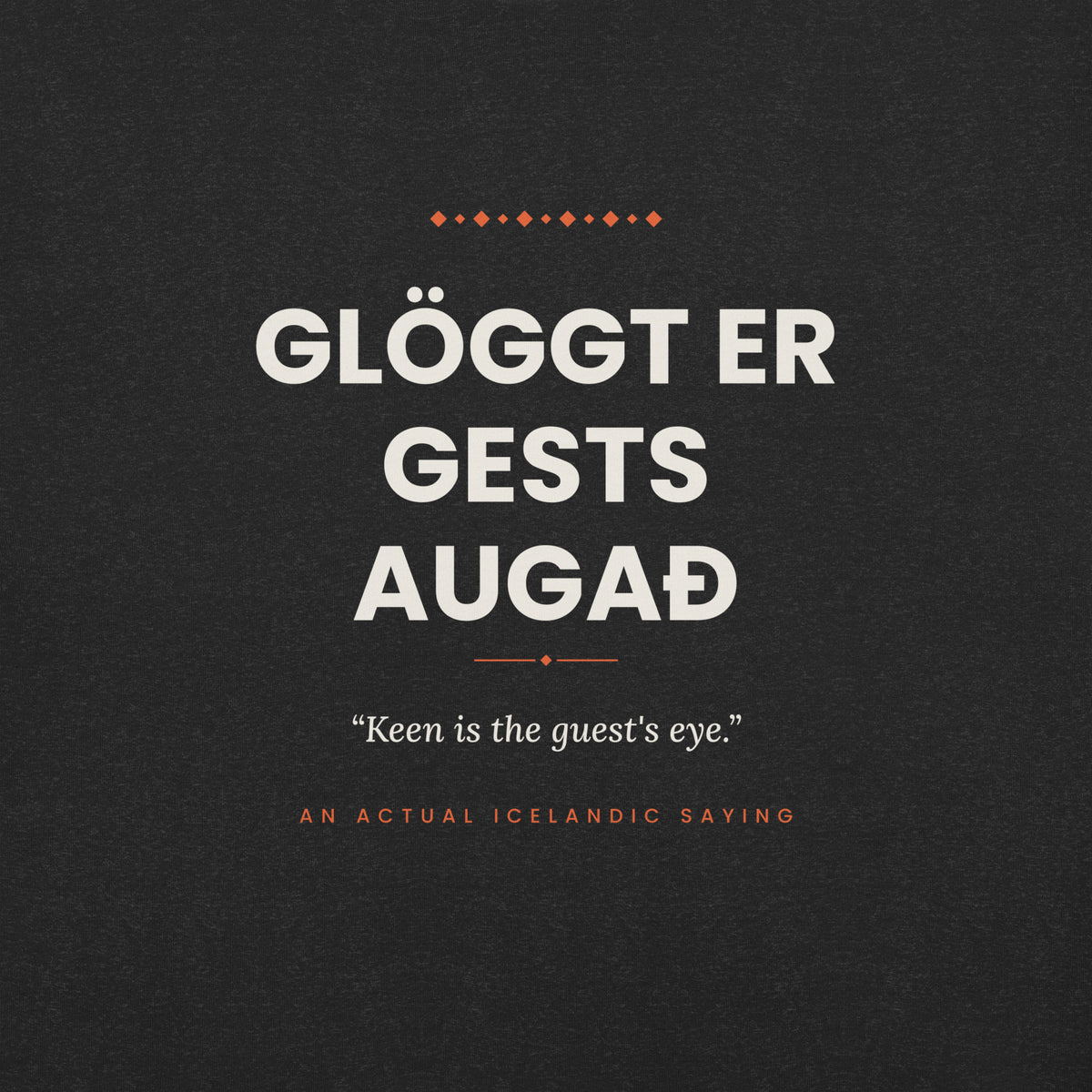 Close-up of the Glöggt er gests augað front print, showing cream lettering, English translation and coral accents on Black Heather fabric.