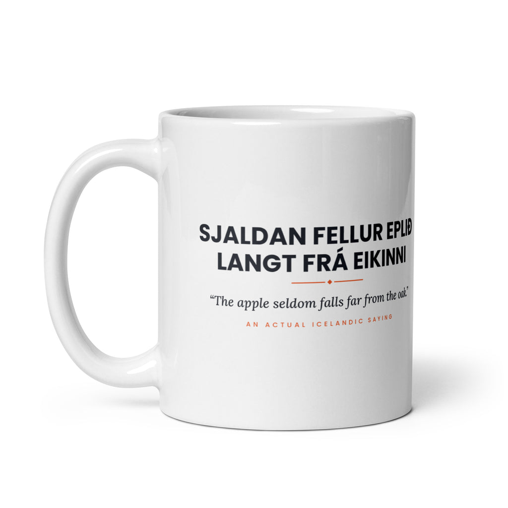White 11 oz Sjaldan fellur eplið langt frá eikinni mug, handle on the left, showing the repeated saying on the other side.