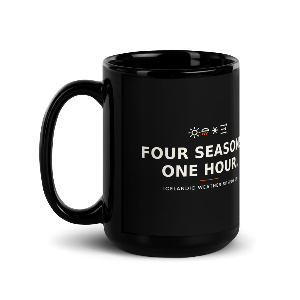 Black 15 oz Four Seasons. One Hour. mug, handle on the left, showing the printed slogan.