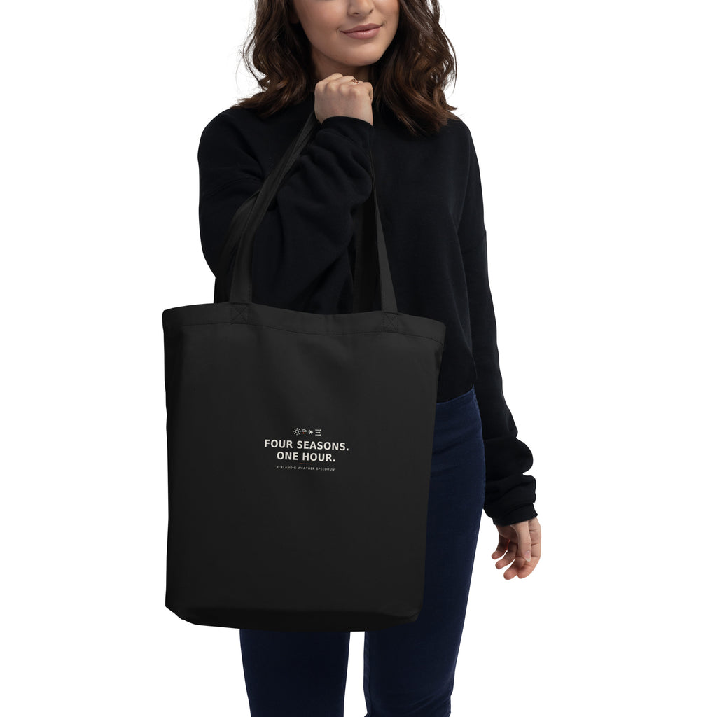 Model carrying the Black Four Seasons. One Hour. tote, showing the front print and the bag in use.