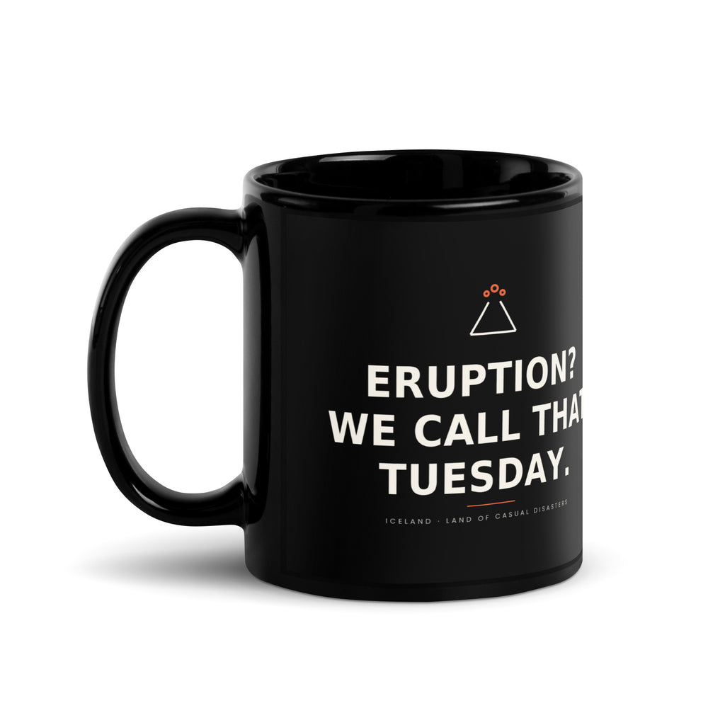Black 11 oz Eruption? We Call That Tuesday. mug, handle on the left, showing the printed slogan.