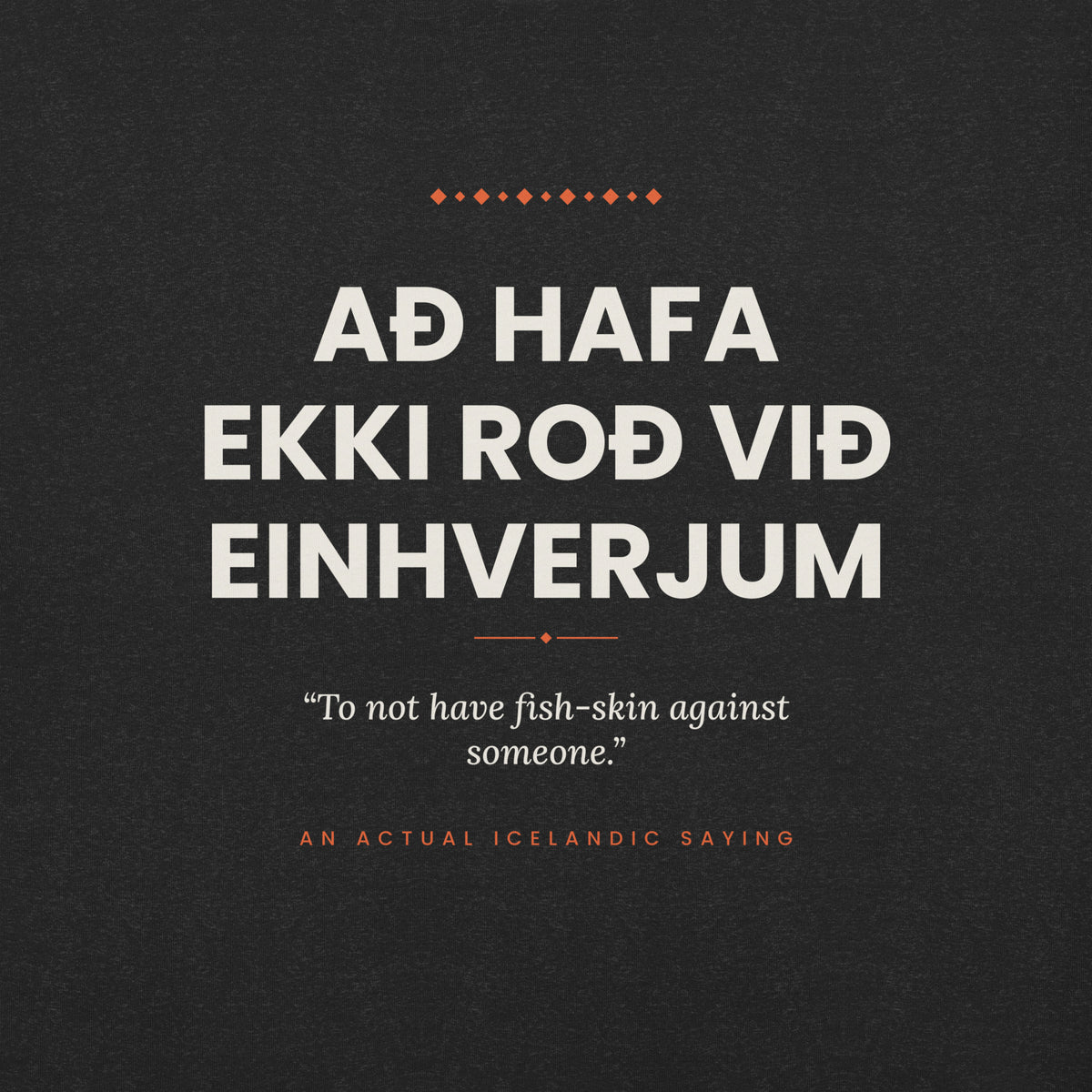 Close-up of the Að hafa ekki roð við einhverjum front print, showing cream lettering, English translation and coral accents on Black Heather fabric.