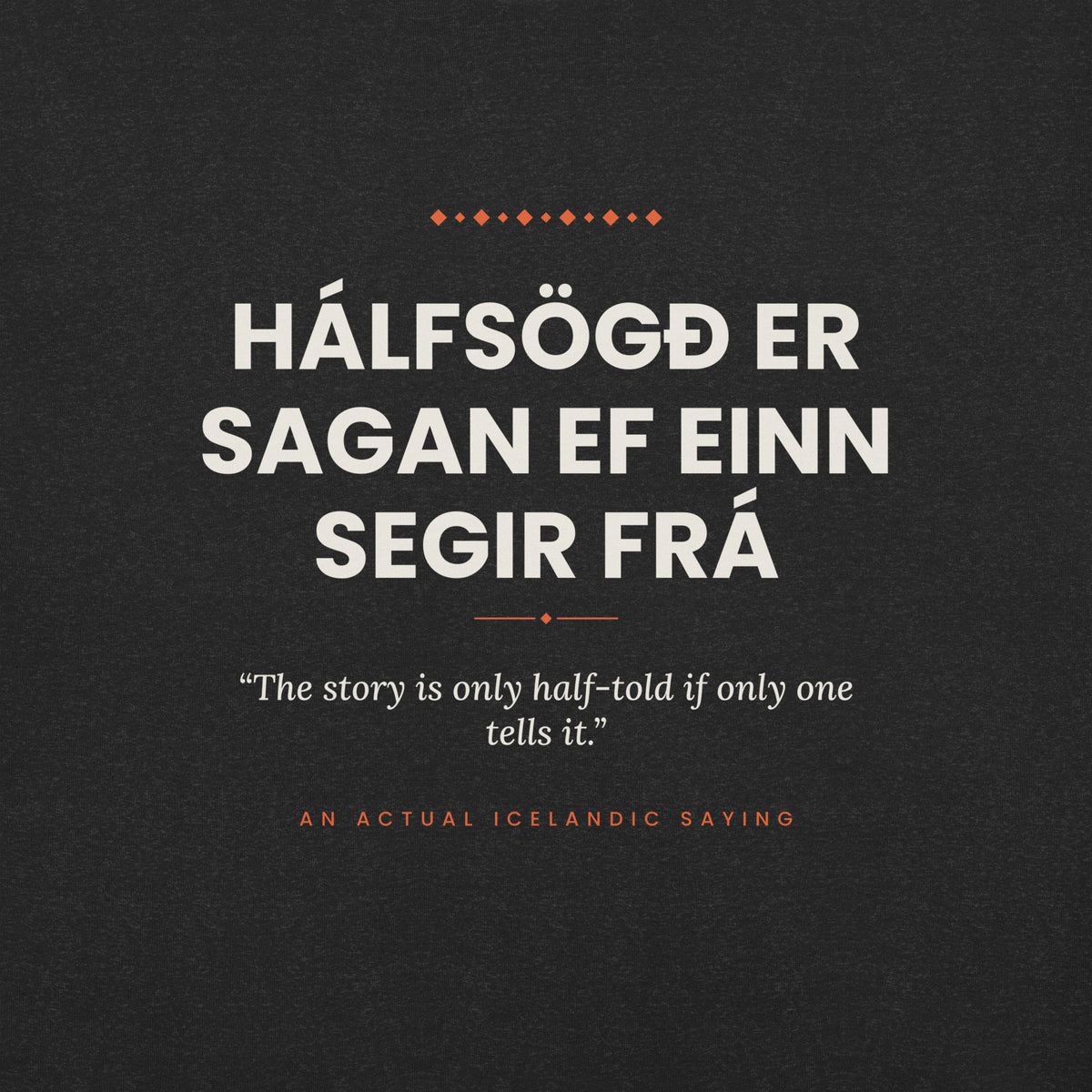 Close-up of the Hálfsögð er sagan ef einn segir frá front print, showing cream lettering, English translation and coral accents on Black Heather fabric.