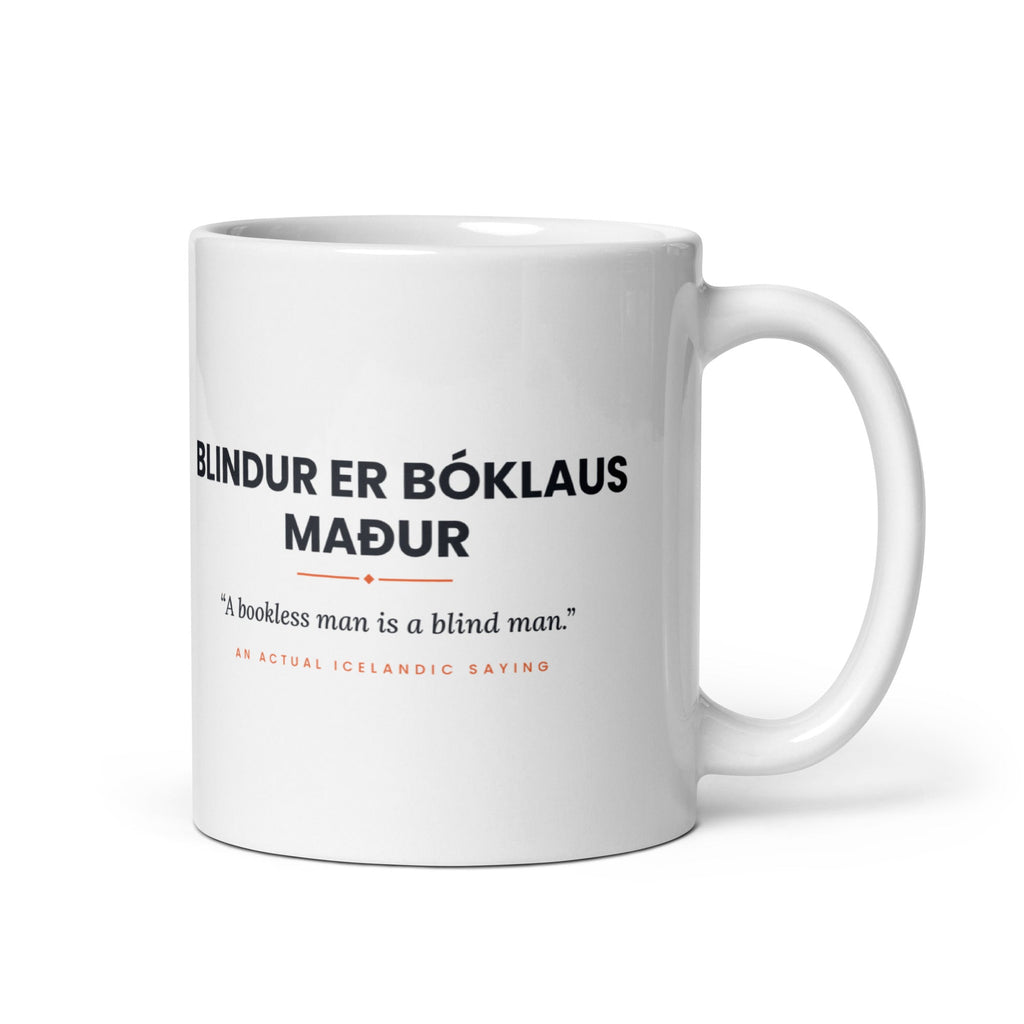 White 11 oz Blindur er bóklaus maður mug, handle on the right, showing black lettering, English translation and coral accents.