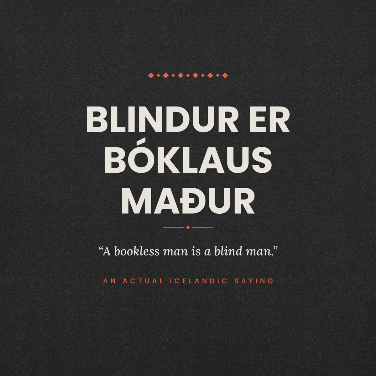 Close-up of the Blindur er bóklaus maður front print, showing cream lettering, English translation and coral accents on Black Heather fabric.