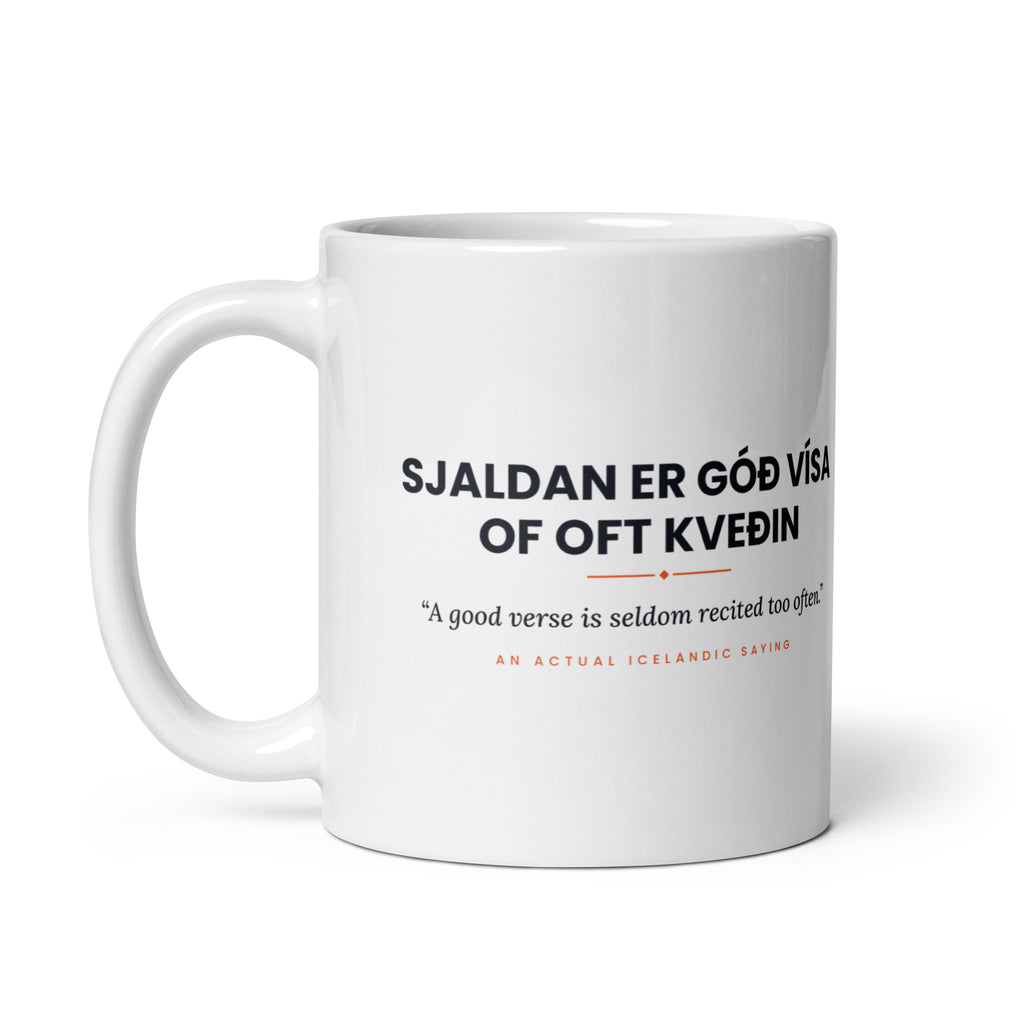 White 11 oz Sjaldan er góð vísa of oft kveðin mug, handle on the left, showing the repeated saying on the other side.