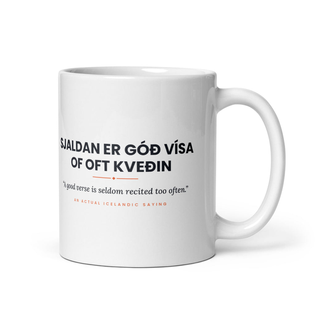 White 11 oz Sjaldan er góð vísa of oft kveðin mug, handle on the right, showing black lettering, English translation and coral accents.