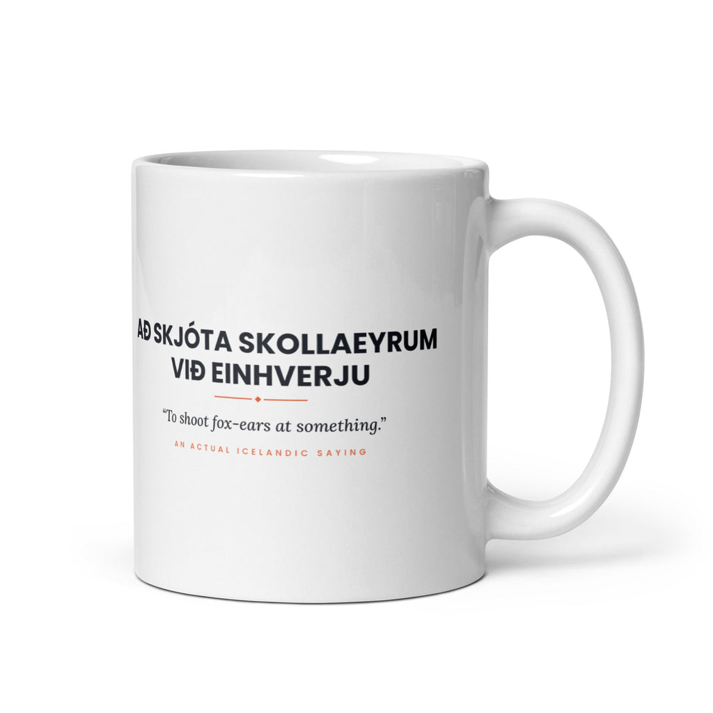 White 11 oz Að skjóta skollaeyrum við einhverju mug, handle on the right, showing black lettering, English translation and coral accents.