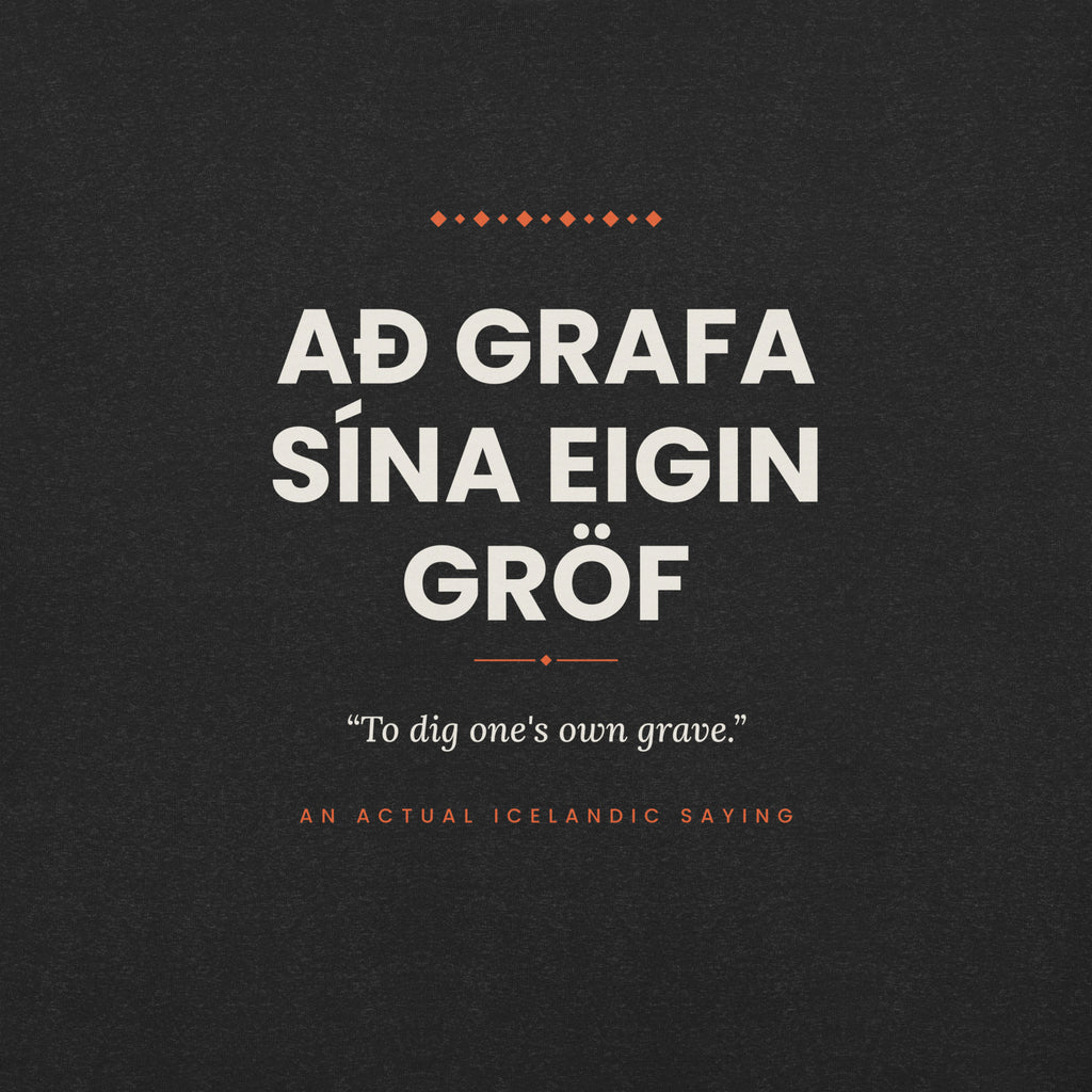 Close-up of the Að grafa sína eigin gröf front print, showing cream lettering, English translation and coral accents on Black Heather fabric.