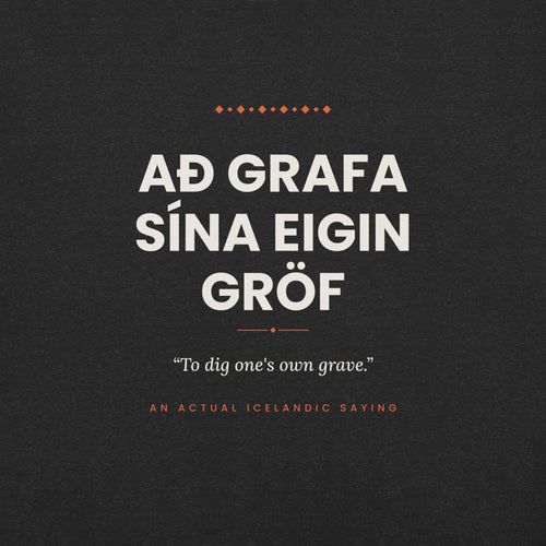 Close-up of the Að grafa sína eigin gröf front print, showing cream lettering, English translation and coral accents on Black Heather fabric.