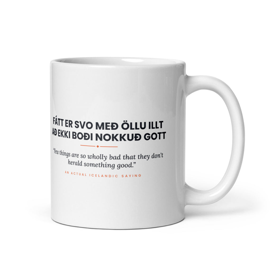White 11 oz Fátt er svo með öllu illt að ekki boði nokkuð gott mug, handle on the right, showing black lettering, English translation and coral accents.