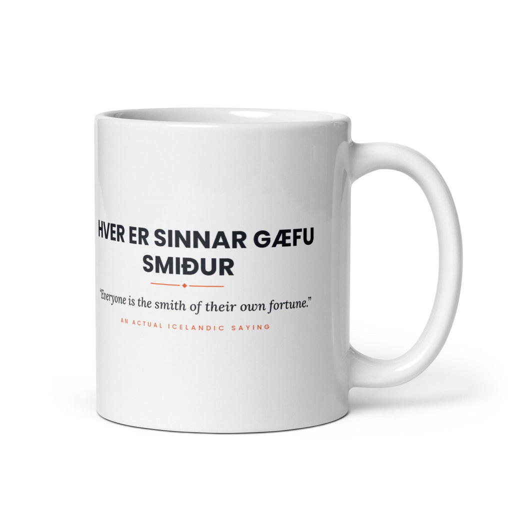 White 11 oz Hver er sinnar gæfu smiður mug, handle on the right, showing black lettering, English translation and coral accents.