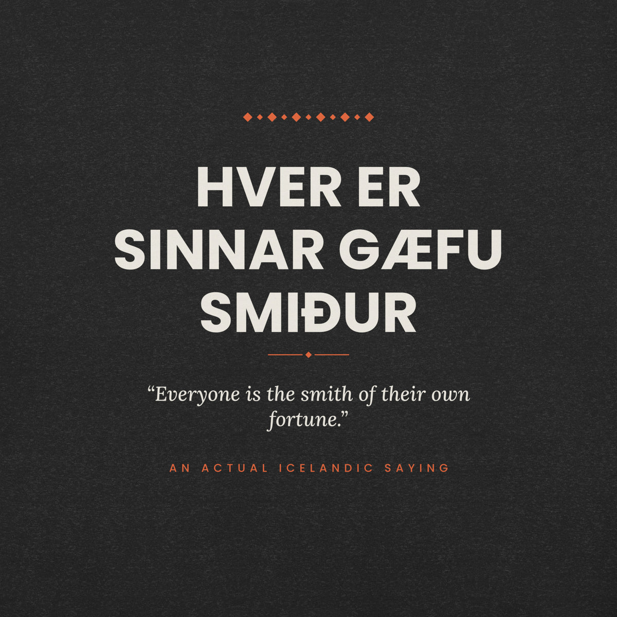 Close-up of the Hver er sinnar gæfu smiður front print, showing cream lettering, English translation and coral accents on Black Heather fabric.