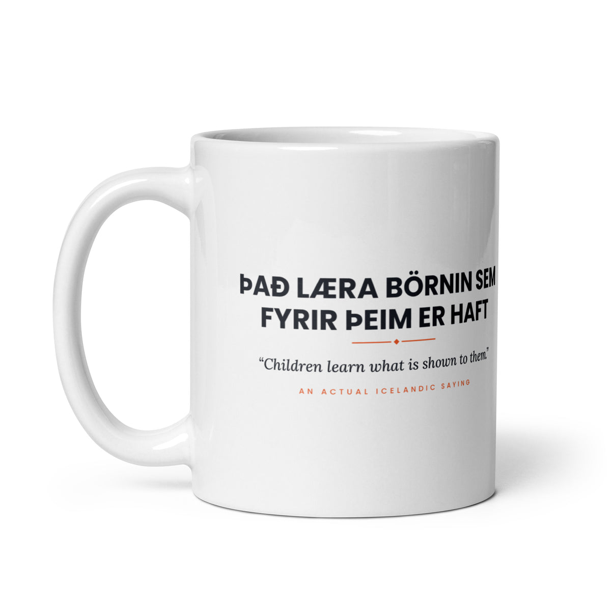 White 11 oz Það læra börnin sem fyrir þeim er haft mug, handle on the left, showing the repeated saying on the other side.