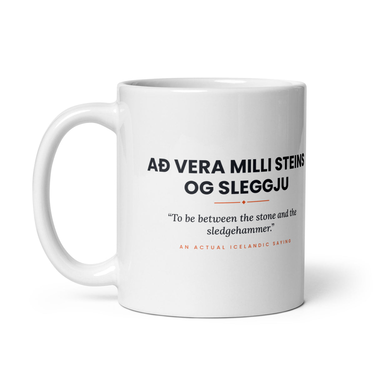 White 11 oz Að vera milli steins og sleggju mug, handle on the left, showing the repeated saying on the other side.