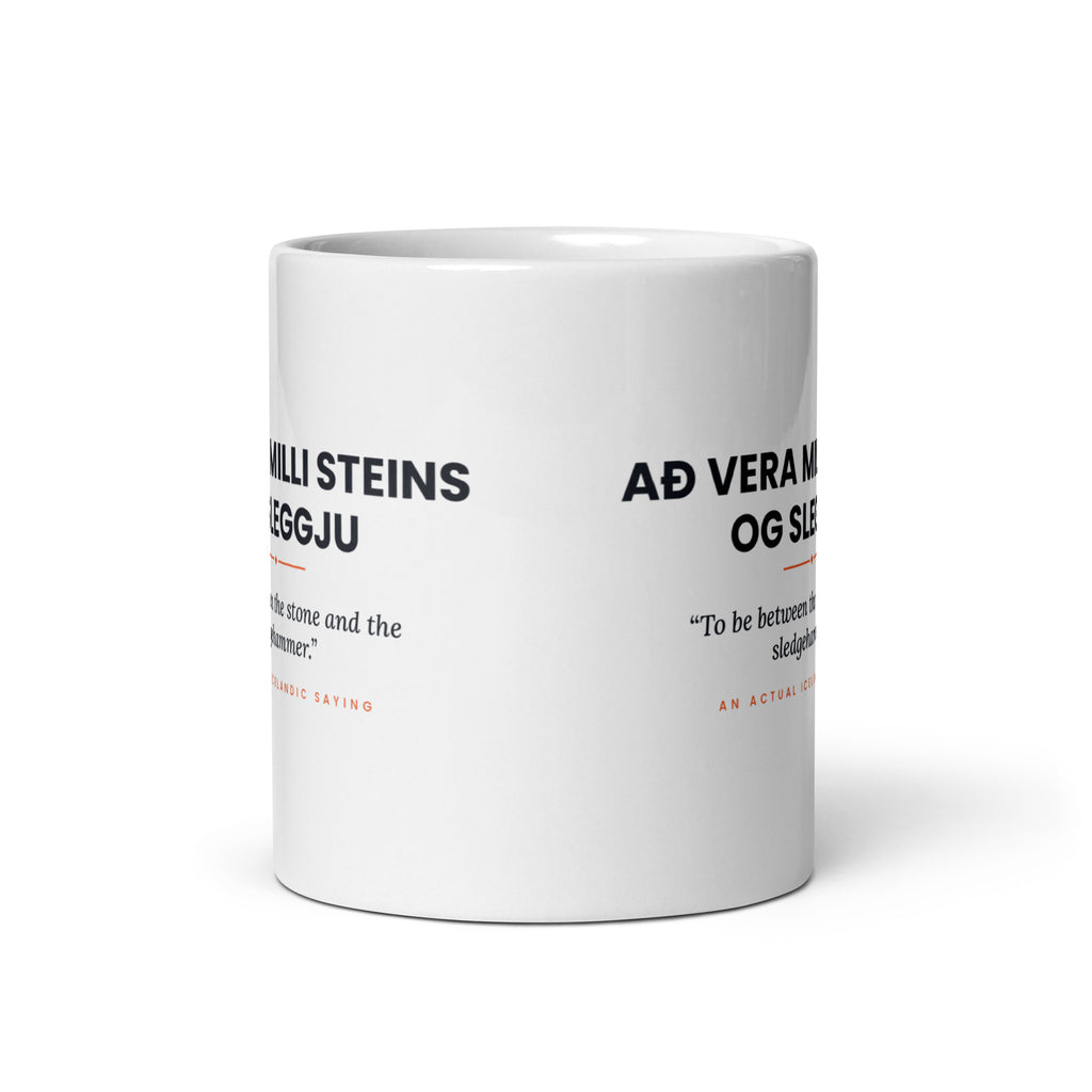 View opposite the handle of the white 11 oz Að vera milli steins og sleggju mug, showing the gap between the two repeats of the design.