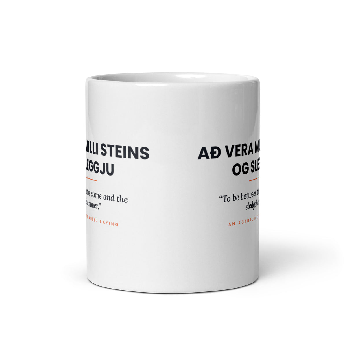 View opposite the handle of the white 11 oz Að vera milli steins og sleggju mug, showing the gap between the two repeats of the design.