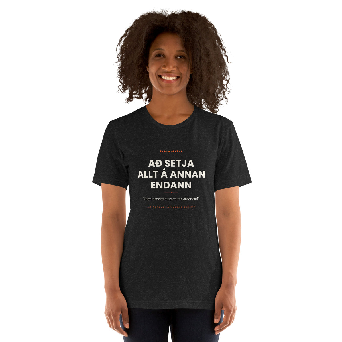 Female model wearing the Black Heather Að setja allt á annan endann tee, showing the front print and unisex fit.