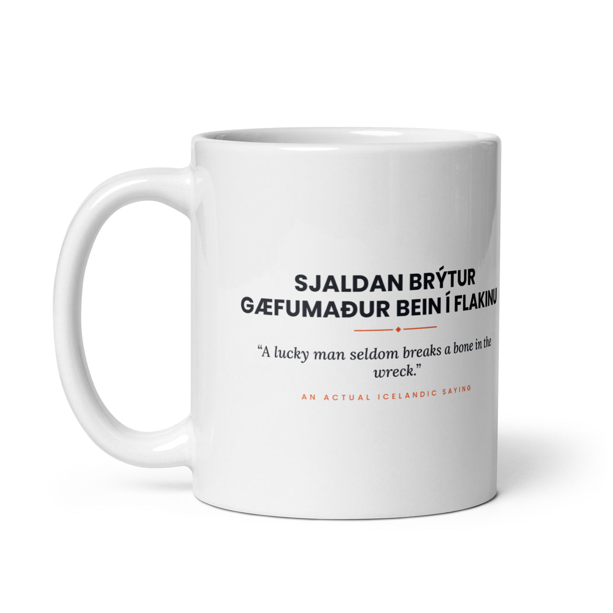 White 11 oz Sjaldan brýtur gæfumaður bein í flakinu mug, handle on the left, showing the repeated saying on the other side.