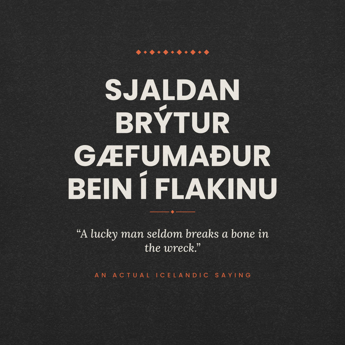 Close-up of the Sjaldan brýtur gæfumaður bein í flakinu front print, showing cream lettering, English translation and coral accents on Black Heather fabric.