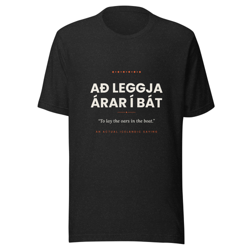 Front view of the Black Heather Að leggja árar í bát tee, with cream lettering, English translation and coral accents.