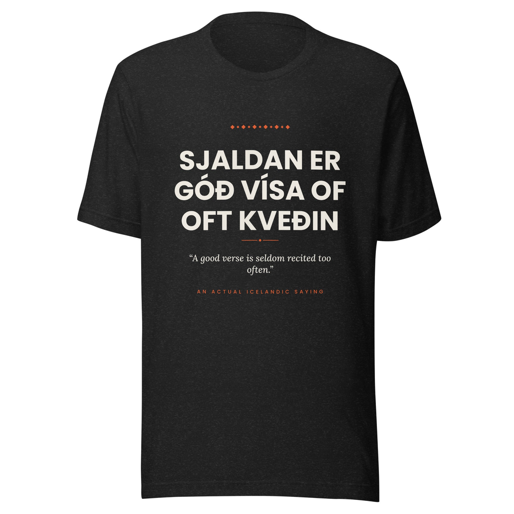 Front view of the Black Heather Sjaldan er góð vísa of oft kveðin tee, with cream lettering, English translation and coral accents.