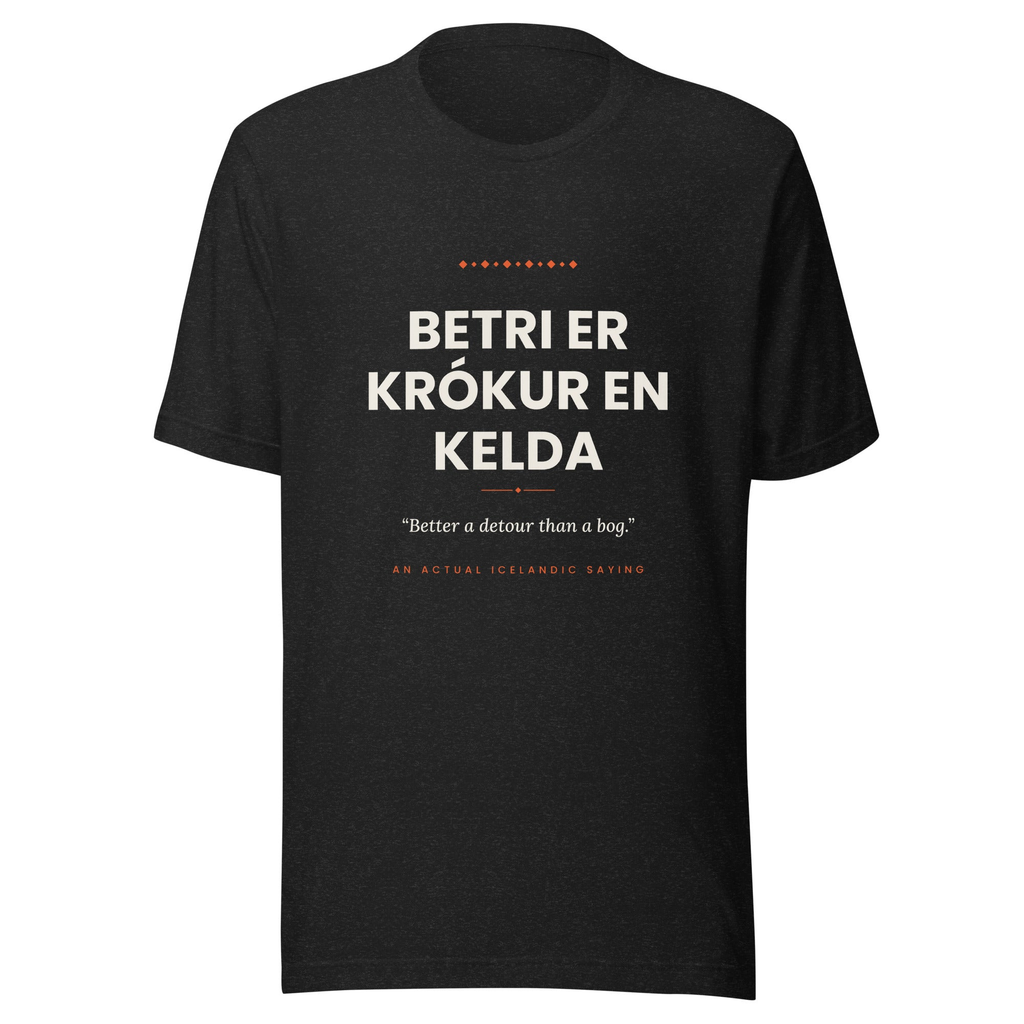 Front view of the Black Heather Betri er krókur en kelda tee, with cream lettering, English translation and coral accents.