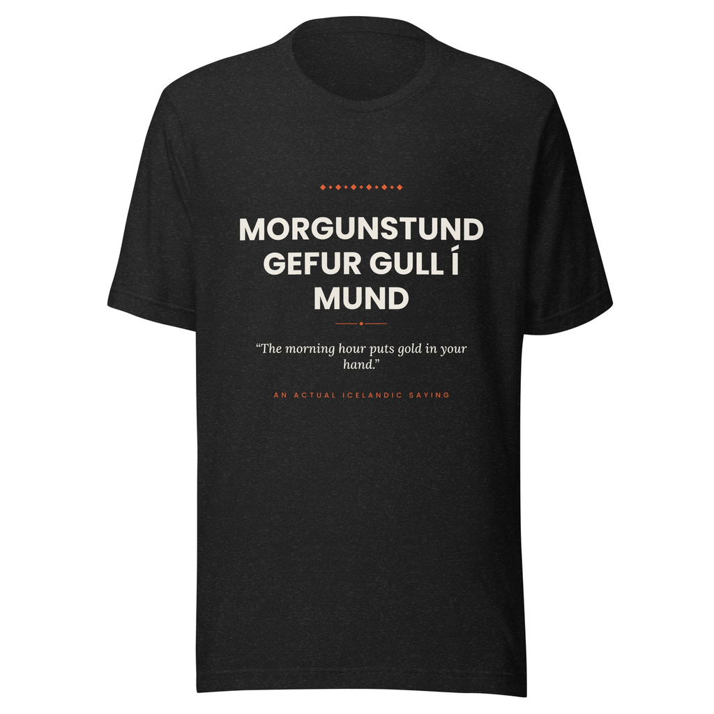 Front view of the Black Heather Morgunstund gefur gull í mund tee, with cream lettering, English translation and coral accents.