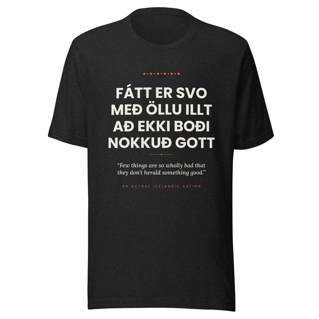 Front view of the Black Heather Fátt er svo með öllu illt að ekki boði nokkuð gott tee, with cream lettering, English translation and coral accents.
